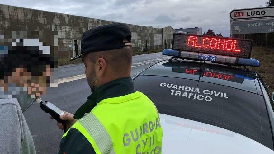 Un agente somete a una prueba de alcoholemia a una mujer que iba a buscar a sus hijos al colegio en Guitiriz.