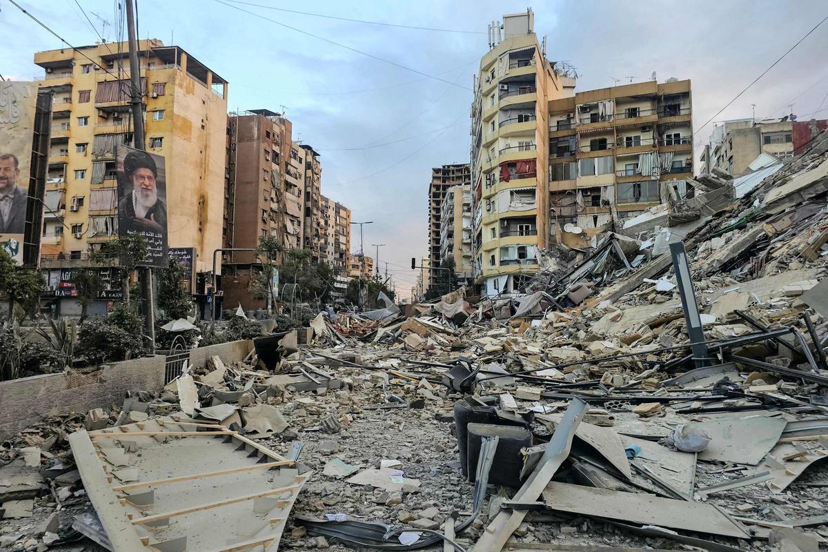 Destrucción tras un bombardeo israelí en un suburbio al sur de Beirut, en Líbano, con un retrato del líder supremo asesinado de Irán, Alí Jameneí, a la izquierda.
