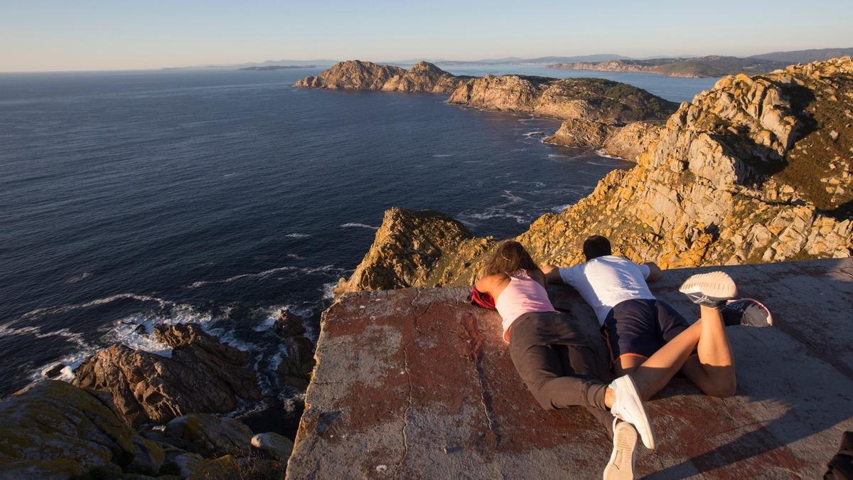 Una pareja disfruta de la espectacular vista de la Ría desde el monte Faro de las Cíes.