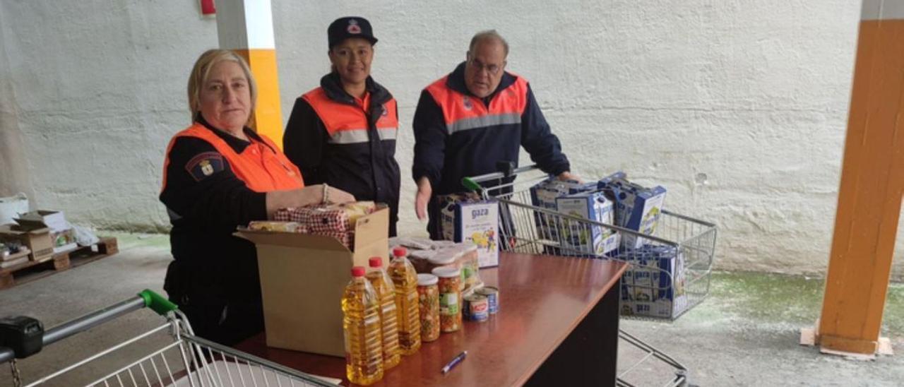 Voluntarios de Protección Civil durante el reparto de los alimentos, en la Sala Lagares. / E. P.