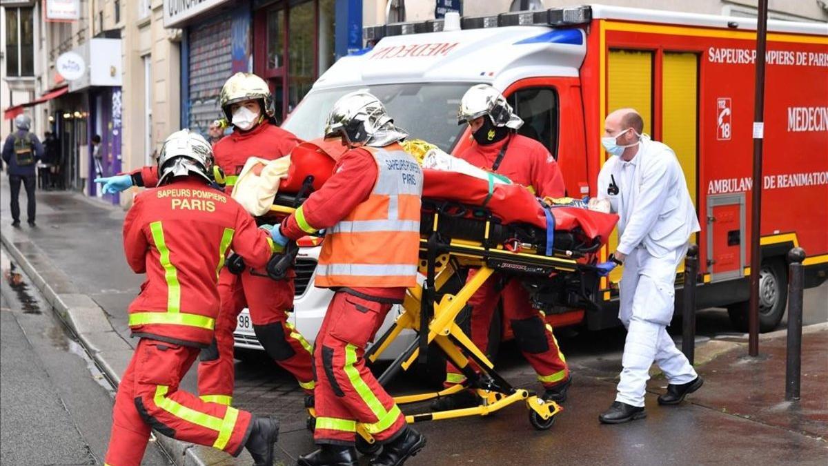 Los bomberos evacúan a un herido en el ataque cerca del semanario Charlie Hebdo.
