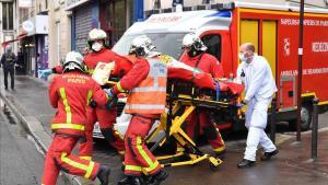 Los bomberos evacúan a un herido en el ataque cerca del semanario Charlie Hebdo.