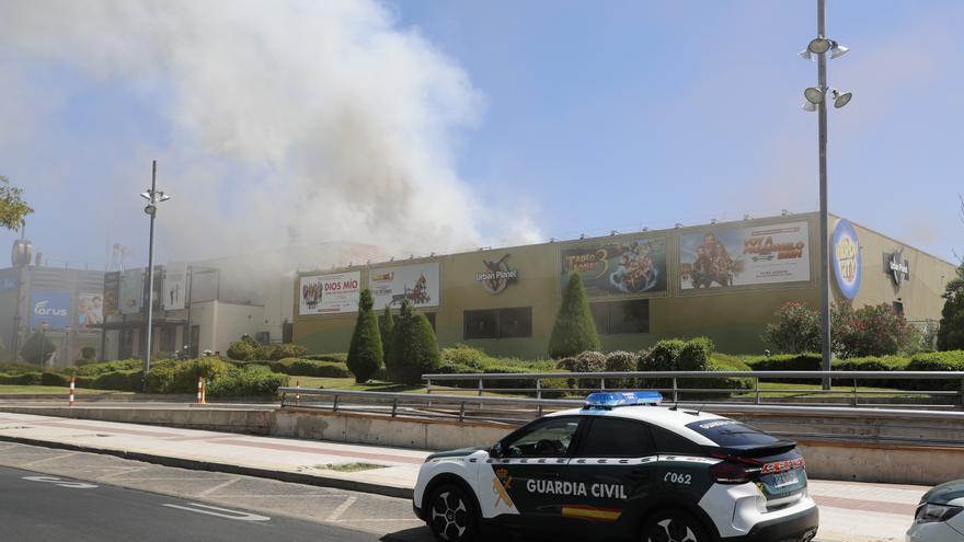 Bomberos trabajan en la extinción de un incendio en un centro comercial de Madrid