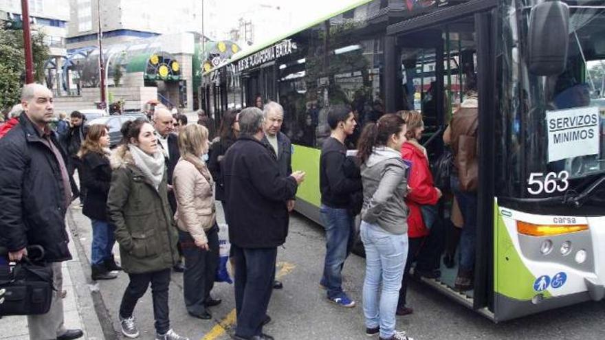 Colas para acceder a un autobús de servicios mínimos en Praza de América.  // J. Santomé