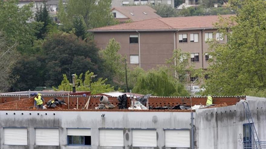 Un operario trabaja en la instalación del tejado del instituto Illa de San Simón, ayer por la mañana.