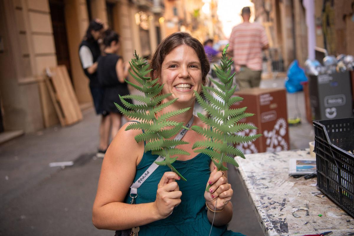 Júlia, vecina de la calle Llibertat, muestra las hojas que está haciendo para las fiestas mayores de Gràcia. Este año, 5 calles del barrio se han unido bajo la temática de ‘El Señor de los Anillos’. Barcelona, 4 de agosto de 2026. Foto: Belén González / EP