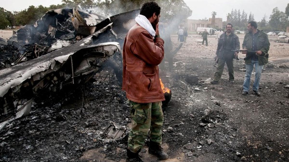 Efectivos de las tropas rebeldes, en el aeropuerto de Benina, tras un bombardeo de Gadafi, el jueves.