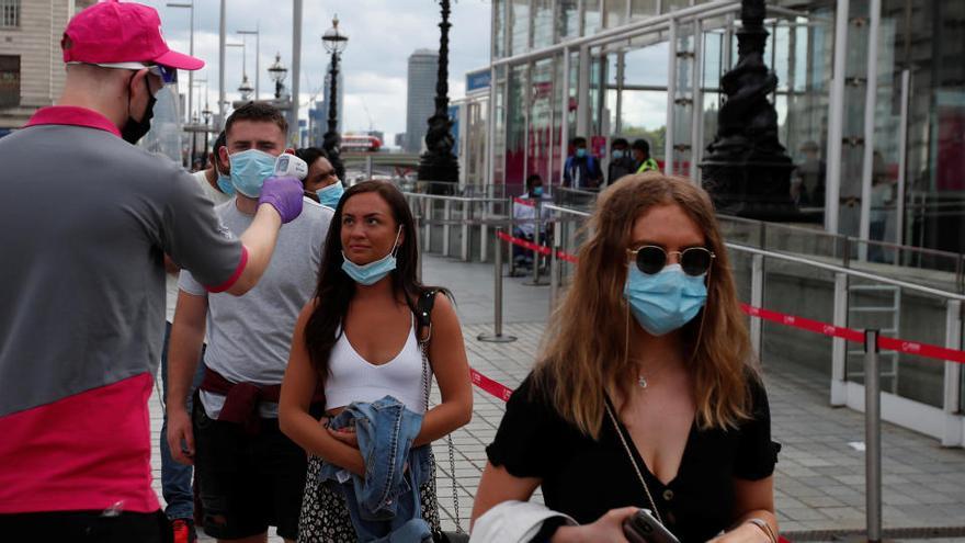 Un empleado toma la temperatura a los empleados del Londen Eye.