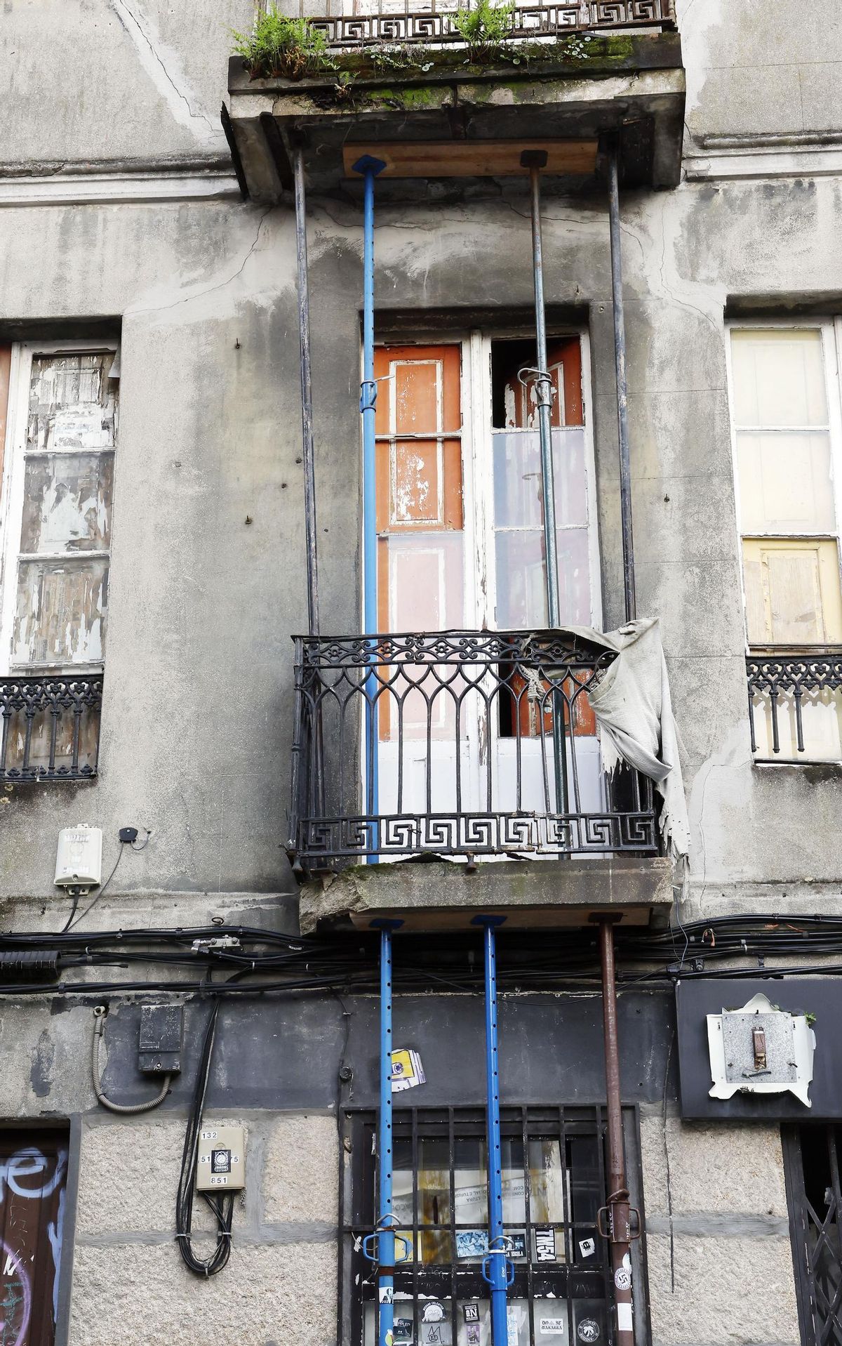 Estado del balcón y fachada del edificio ruinoso situado en el número 4 de la calle Irmandiños, en la zona de Churruca