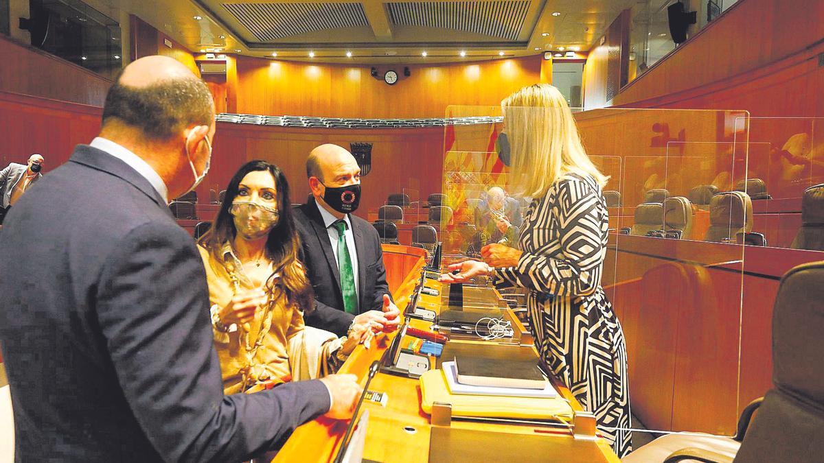 Diputados del PP y Vox conversan en el pleno.