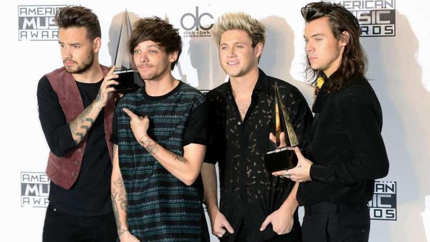 Los miembros de One Direction posan con los premios.