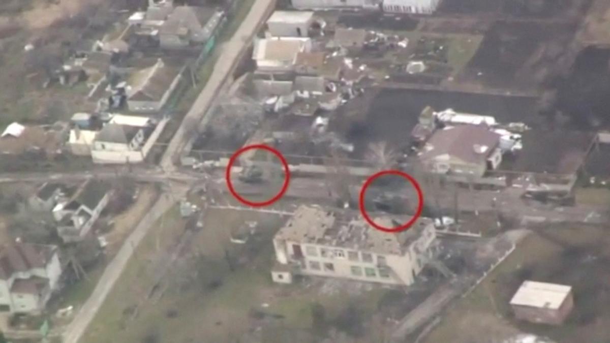 Una vista aérea muestra edificios dañados y vehículos militares en la carretera, en Mariupol.