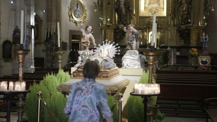 Una feligresa observa la Virgen Dormida de la iglesia de Sant Nicolau