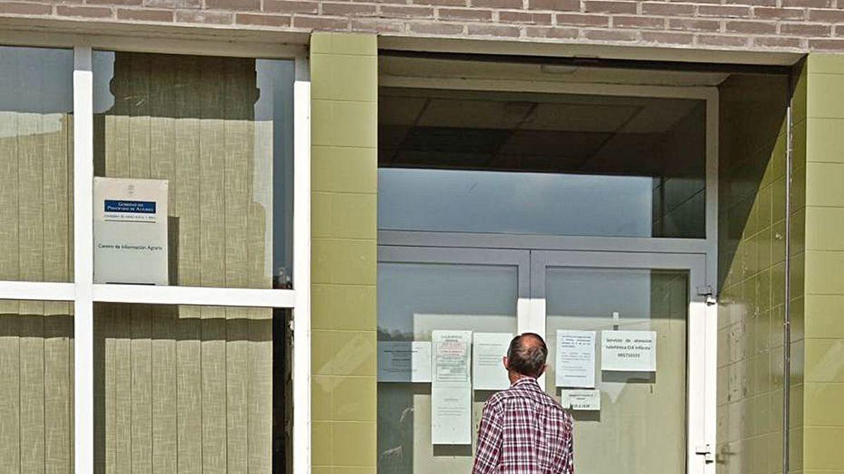 Un usuario, ayer, observando los avisos de la oficina de Medio Rural en Infiesto, cerrada.