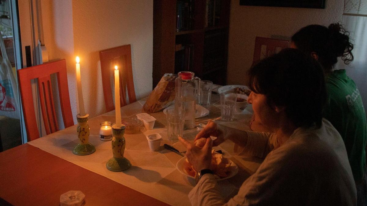 Una família de Xàtiva sopa a la llum de ciris el dia de l'apagada.