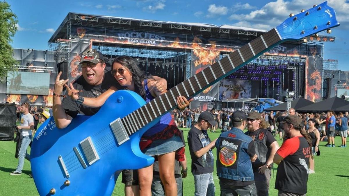 Asistentes al Rock Fest se hacen una fotografía junto a una gran guitarra