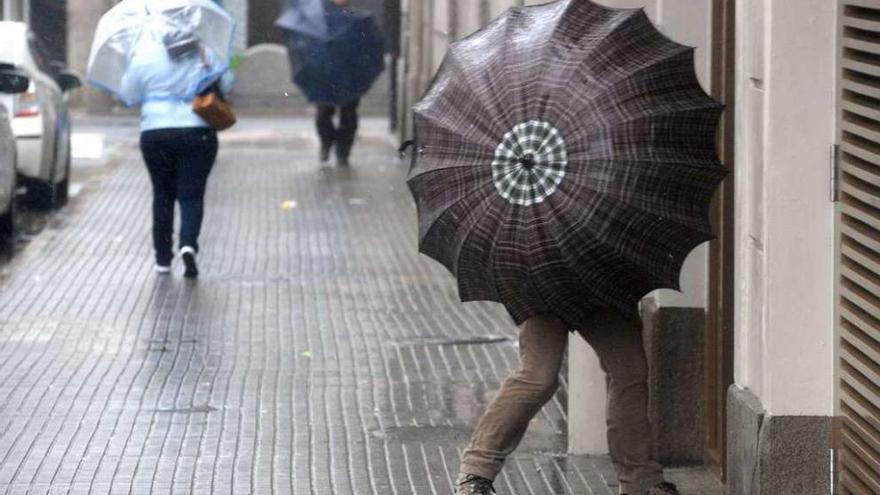 Gente se resguarda de la lluvia en A Coruña.