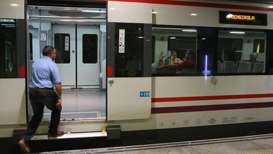 Un hombre se sube a un tren de la línea de Cercanías de Málaga.