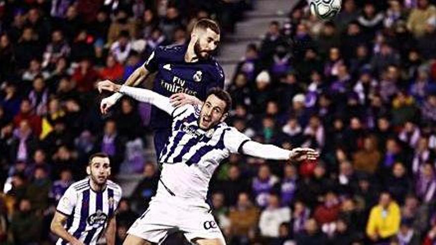 El davanter Karim Benzema (Madrid) disputant una pilota amb Kiko Olivas (Valladolid).