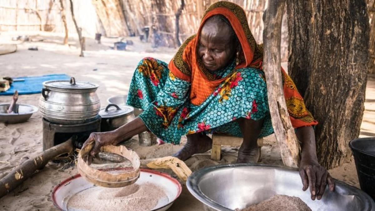 Una mujer africana prepara una comida en su cocina rural.