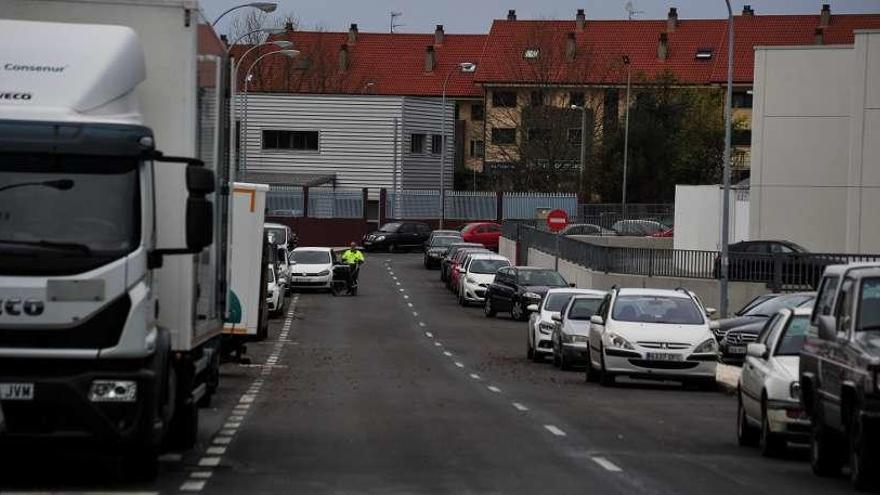 Una hilera de coches aparcados en el carril de circulación del polígono de Trabanca. // Iñaki Abella