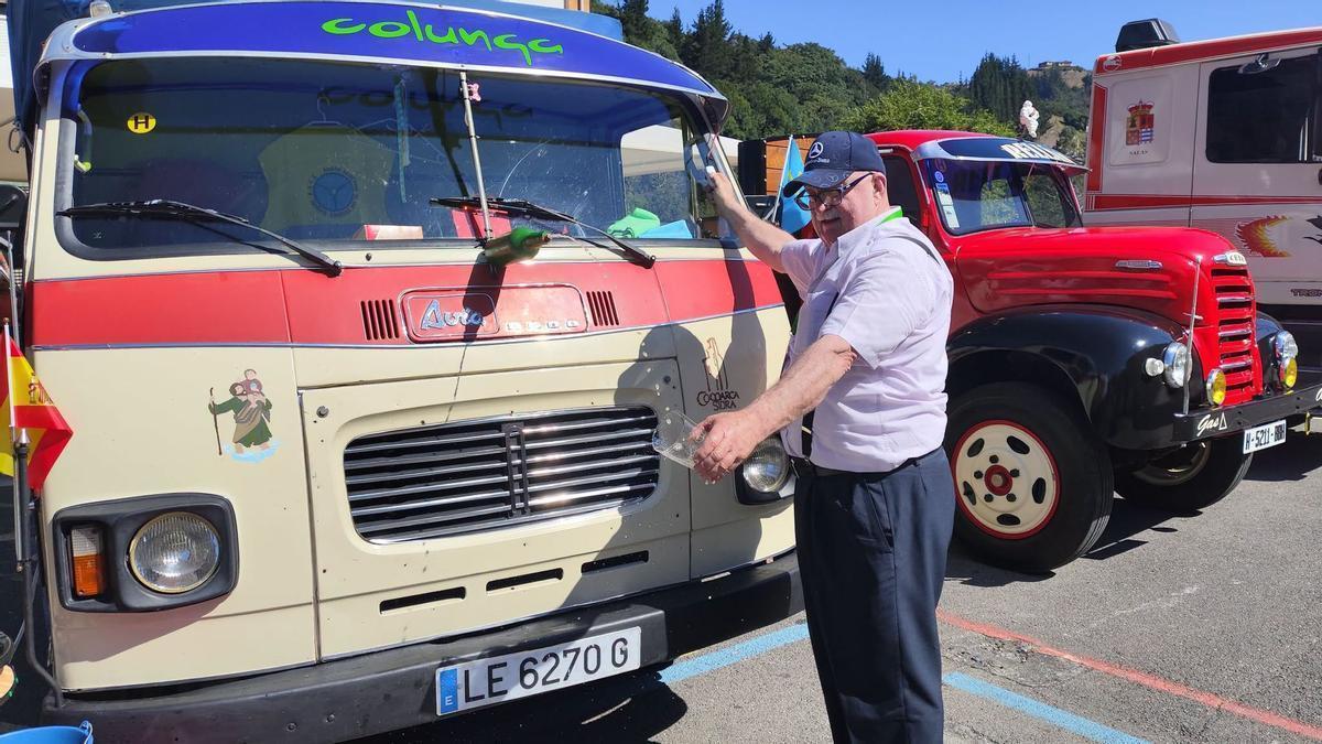 Uno de los participantes de la ruta por Cangas del Narcea escancia sidra en su vehículo.