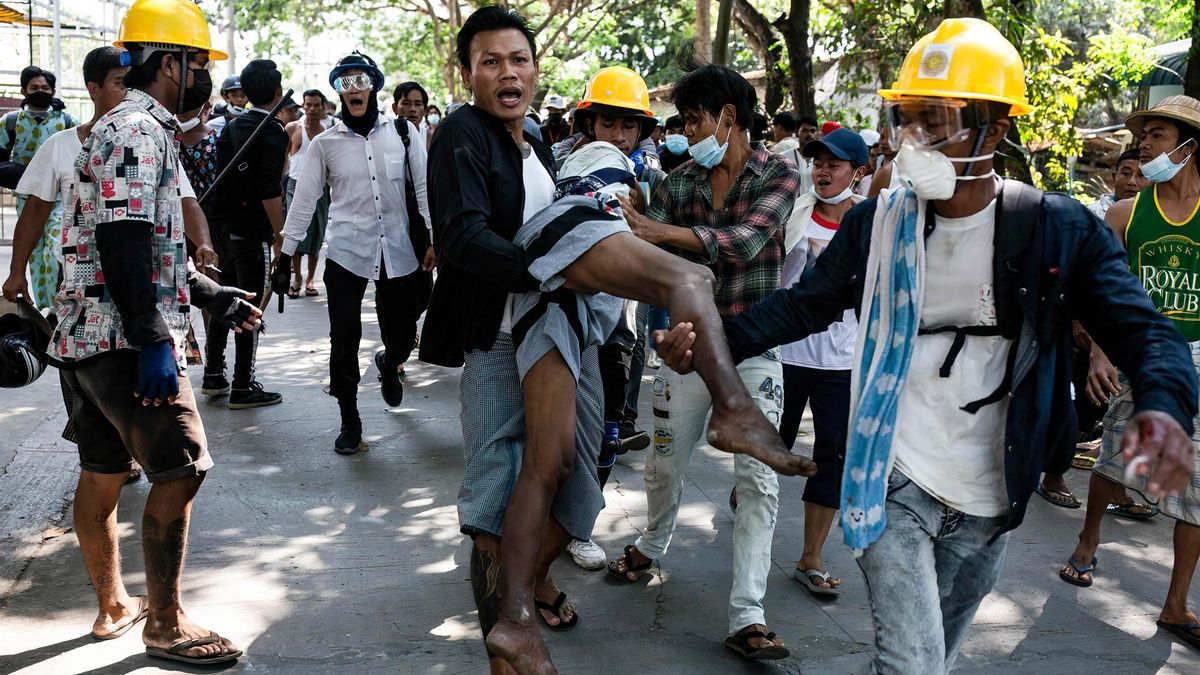 Manifestantes cargan a un hombre herido durante una jornada de protestas en Rangún.