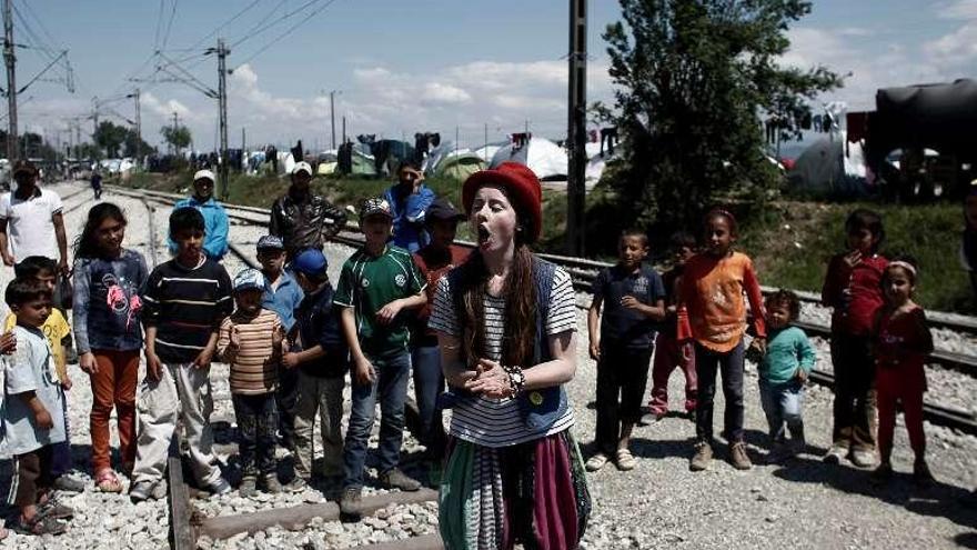 Una joven disfrazada de payaso en el campo de Idomeni. // Reuters