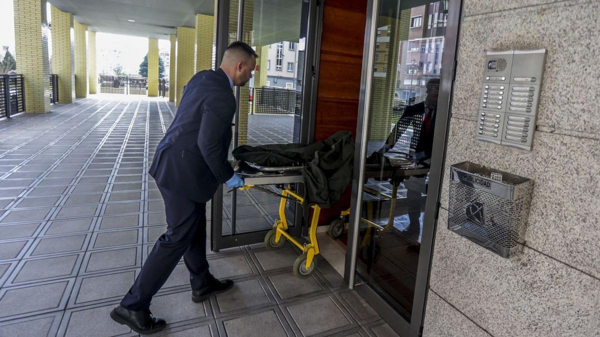 Operarios de la funeraria trasladan el cadáver de Tatiana Coinac.