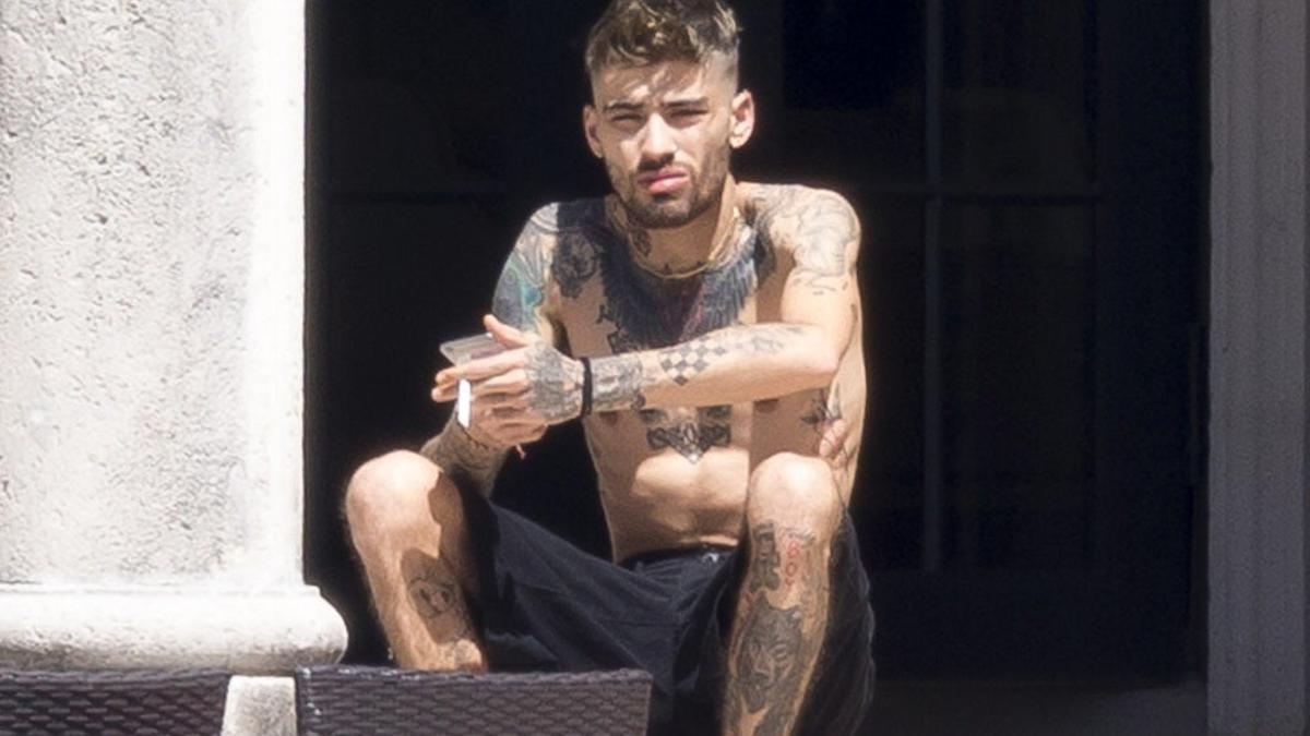 Zayn Malik luce tatuajes mientras se fuma un cigarro