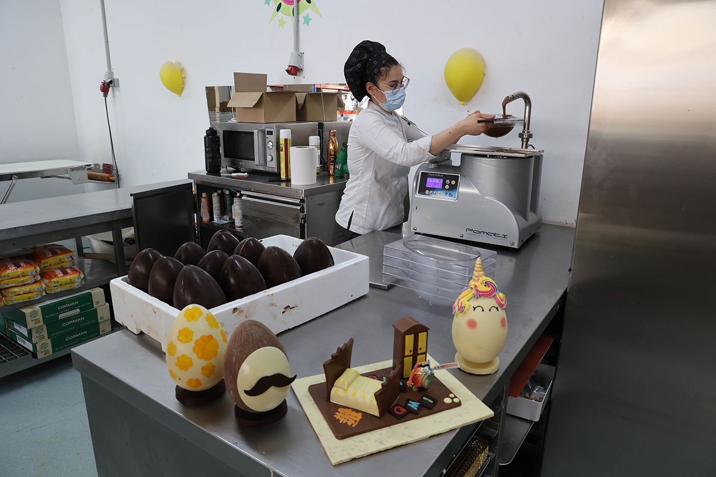 Una confitera, trabajando el chocolate para los  huevos de Pascua en El Trigal.