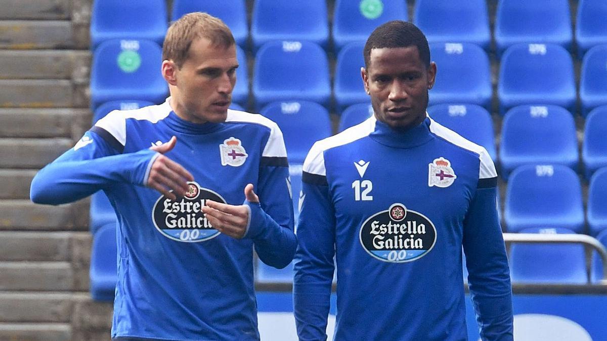 Álex Bergantiños charla con Claudio Beauvue sobre el césped de Riazor. |  // CARLOS PARDELLAS