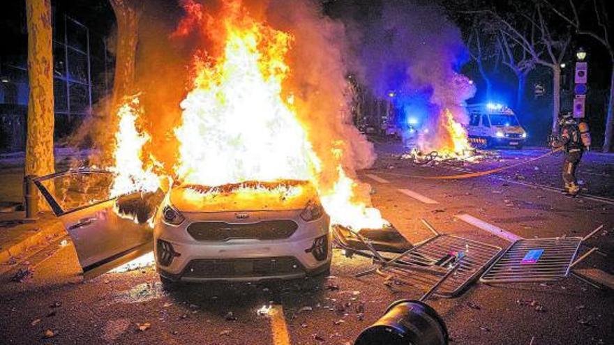 Un cotxe cremant a Barcelona i un bomber apagant un altre foc | MANU MITRU