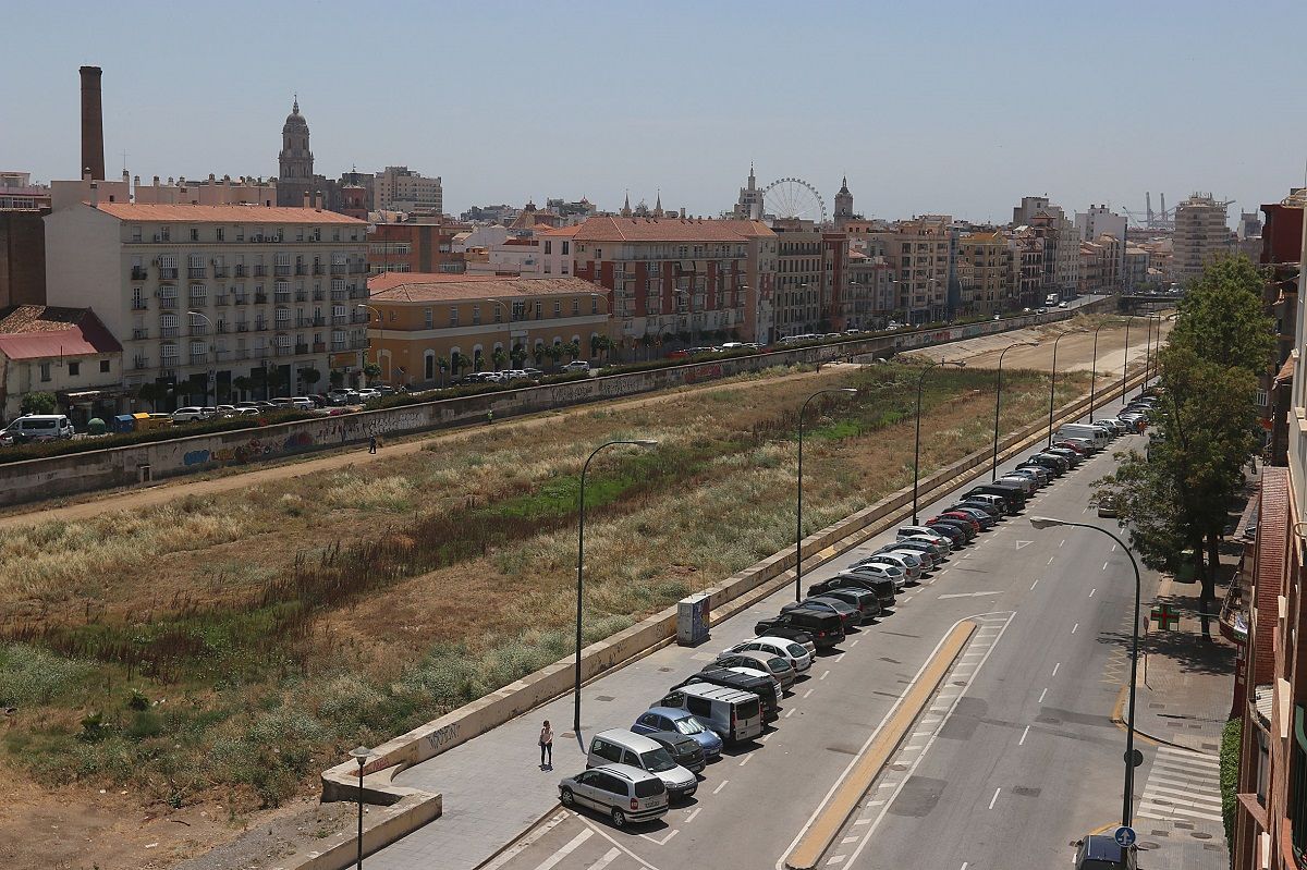 La chimenea de la antigua fábrica (izq.), vista desde el otro lado del río Guadalmedina.