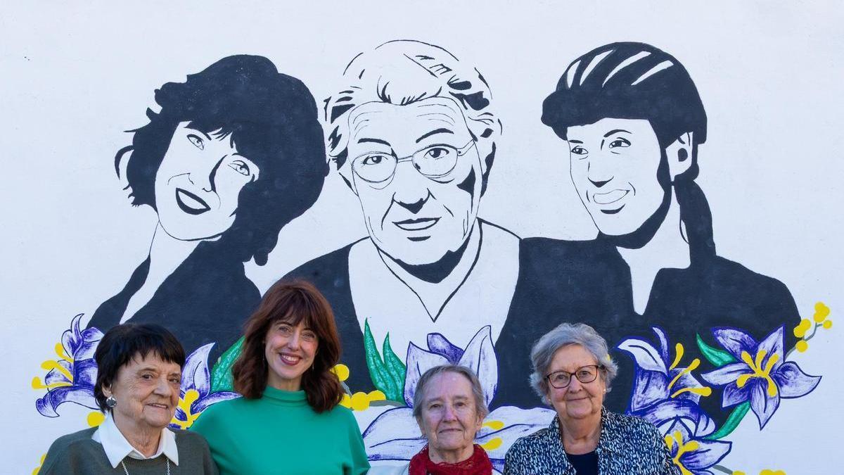 Irene Vallejo con el mural en el que aparece y tres de sus profesoras del IES Goya de Zaragoza.