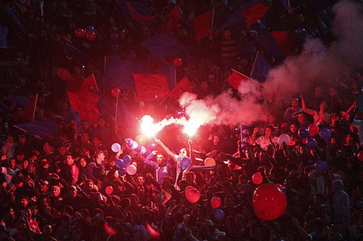 Aficionats de la Universitat de Xile animen el seu equip en el partit contra el Llibertat del Paraguai, corresponent a la tornada dels quarts de final de la Copa Libertadores, a l’Estadi Nacional de Santiago de Xile.