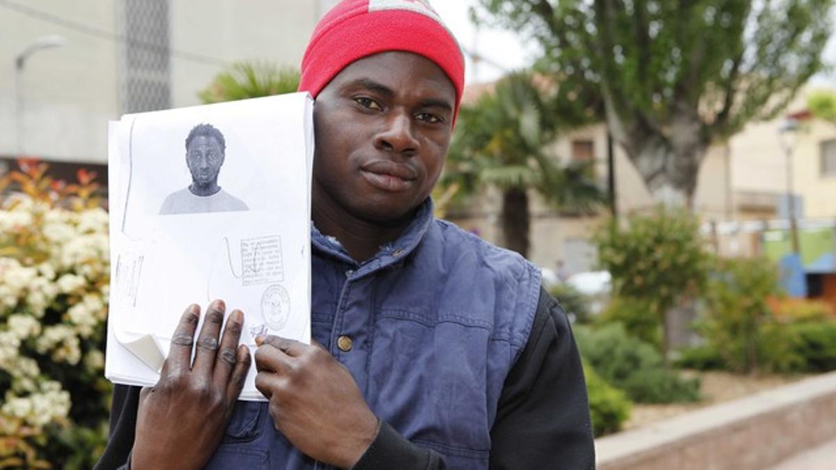 Lamin Darboe muestra una foto del narco que le suplantó la identidad y por el que fue condenado.