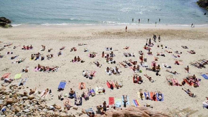 Gente tomando el sol en la playa de Matadero, en A Coruña.