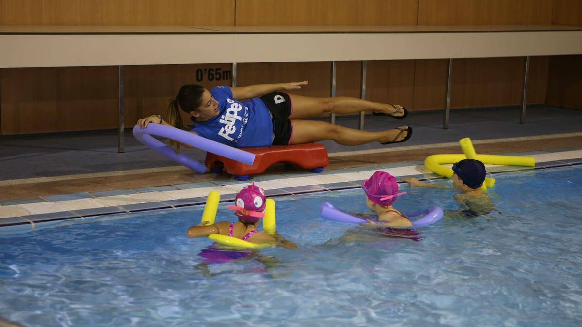 Una monitora dando una clase de natación a menores en una de las piscinas del Complejo Deportivo Felipe VI.