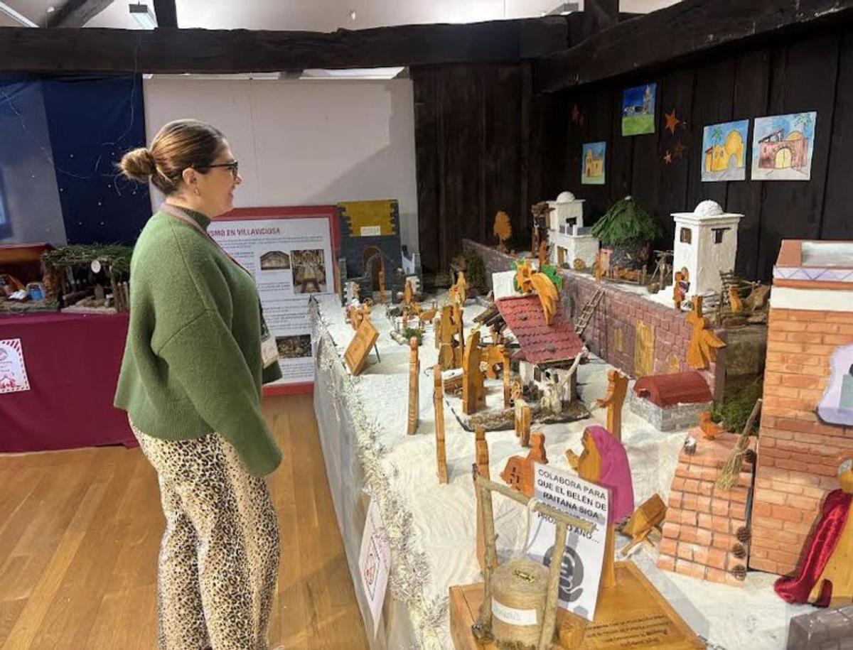 Ana Palenzuela, observando el belén de la Asociación Raitana en la Casa de los Hevia.