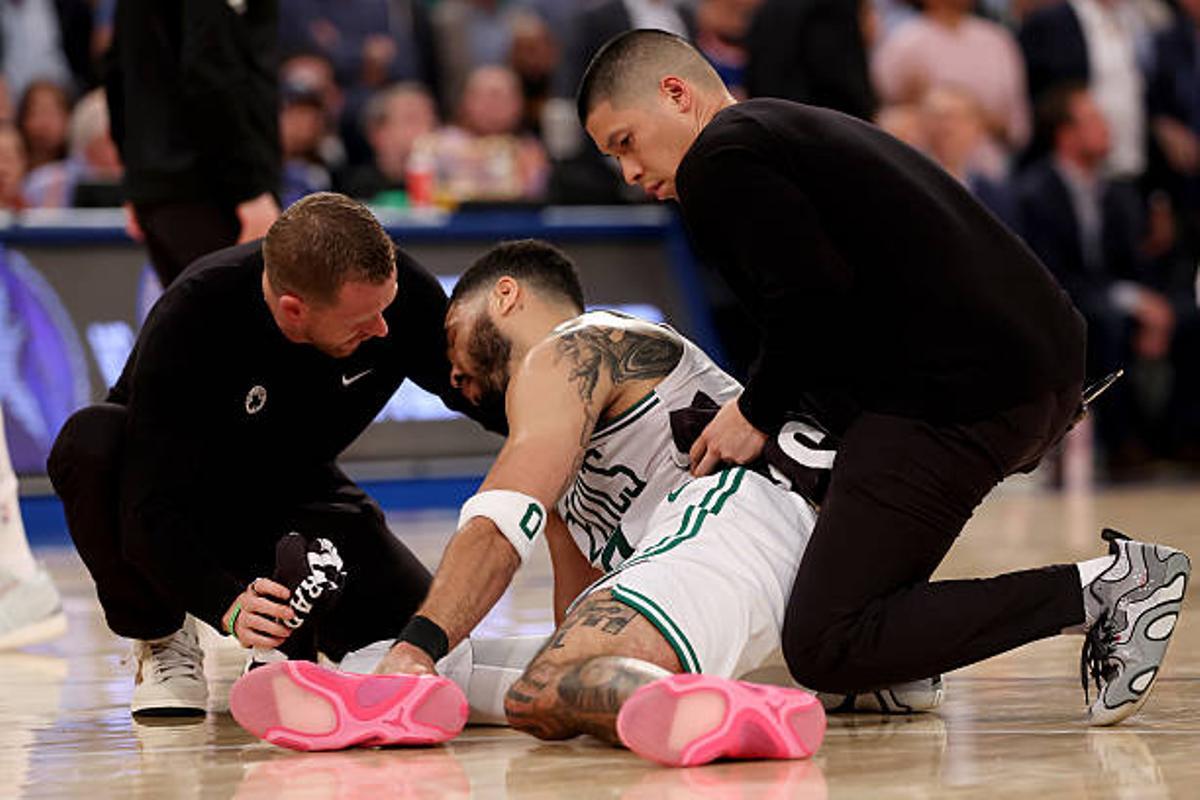 NEW YORK, NEW YORK - MAY 12: Jayson Tatum #0 of the Boston Celtics is looked over on the court after being injured against the New York Knicks during the fourth quarter in Game Four of the Eastern Conference Second Round NBA Playoffs at Madison Square Garden on May 12, 2025 in New York City. NOTE TO USER: User expressly acknowledges and agrees that, by downloading and or using this photograph, User is consenting to the terms and conditions of the Getty Images License Agreement. (Photo by Elsa/Getty Images)