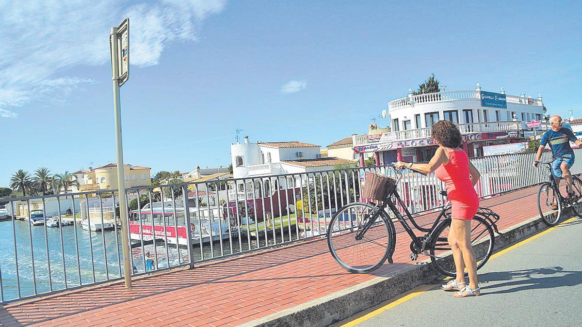 Ciclistes transitant sobre el pont principal de l’avinguda de la República d’Empuriabrava.