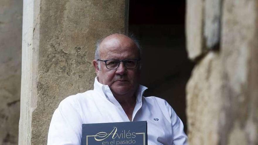 Nardo Villaboy, con el libro &quot;Avilés en el pasado&quot;, en un soportal del casco antiguo.