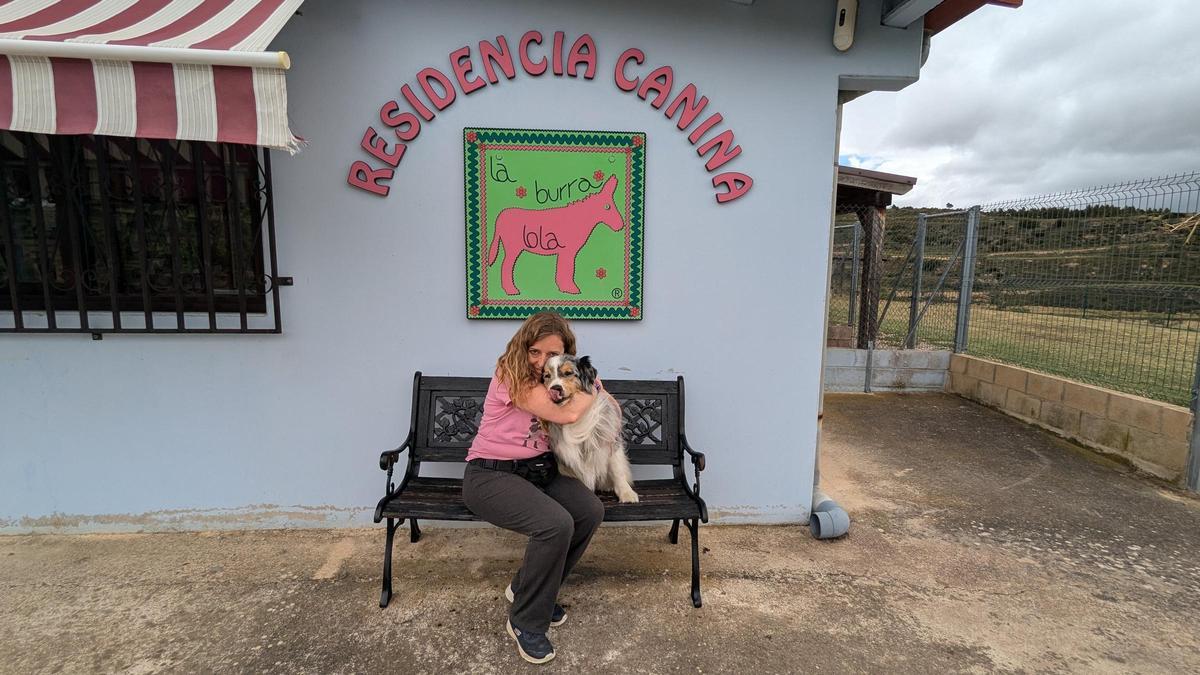 Laura García abraza a uno de sus perros en su residencia canina.