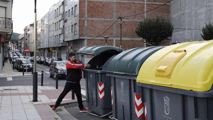 Un joven deposita basura en un contenedor de residuos orgánicos en Silleda. // Bernabé/Javier Lalín