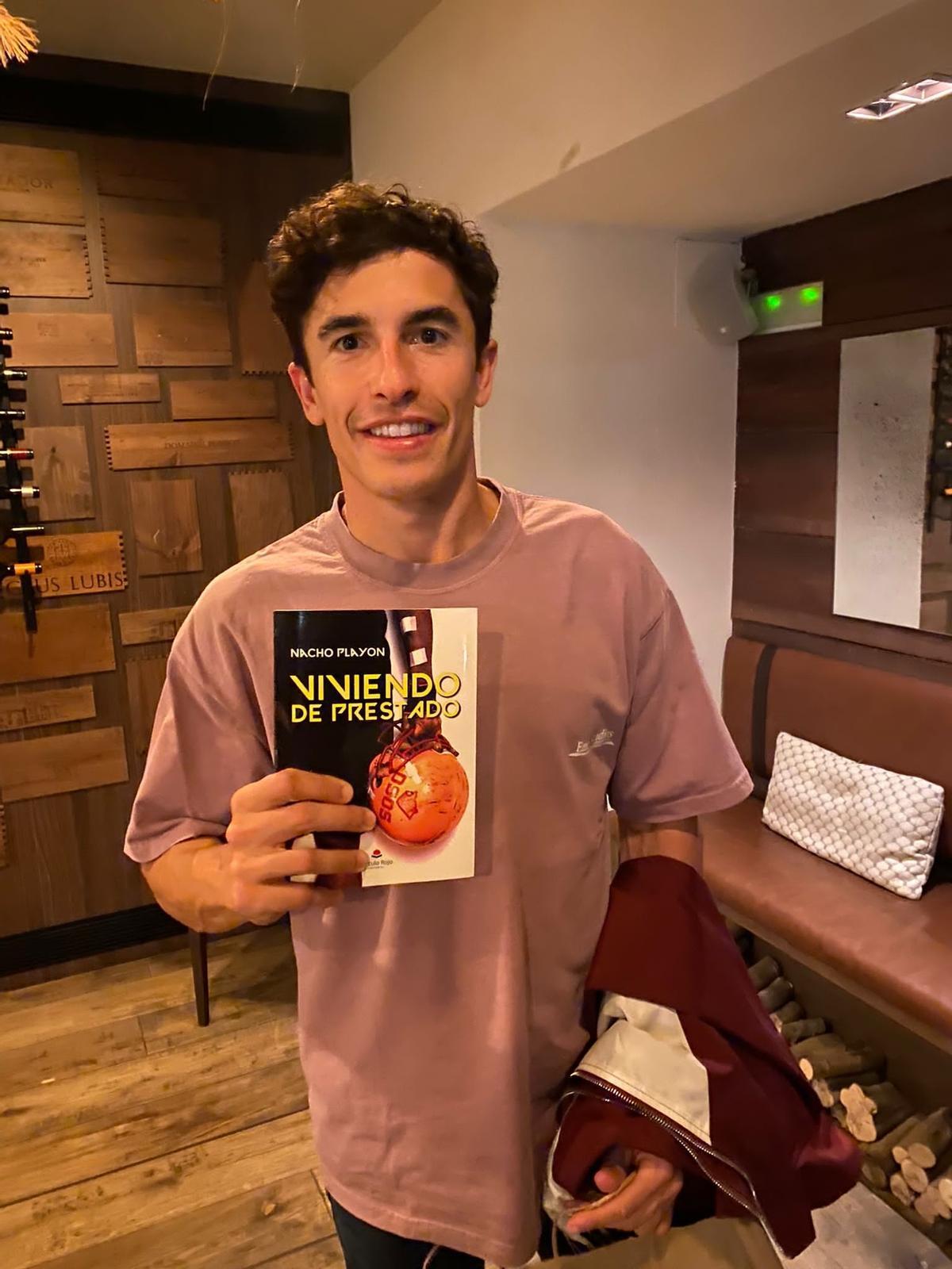 El piloto Marc Márquez, con el libro de Nacho Playón.