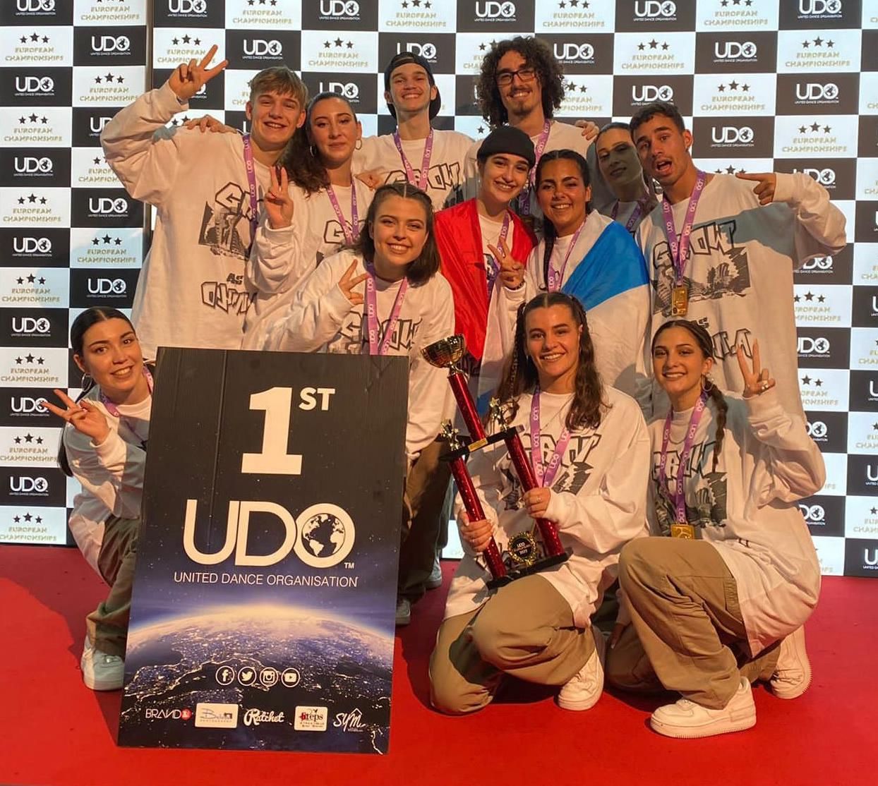 El grupo Grow As Ohana, con las medallas al cuello, posando con el trofeo.