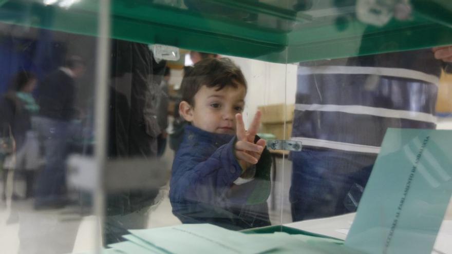 Un niño, junto a una urna electoral en las elecciones andaluzas del 2018.