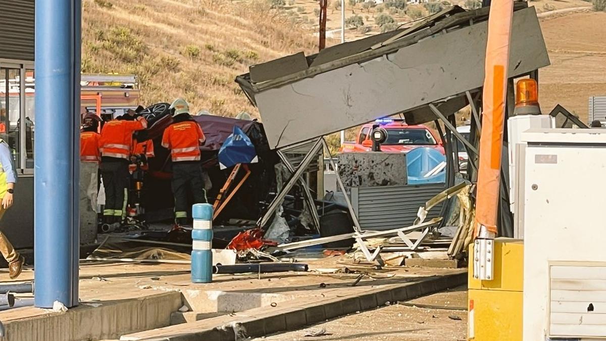 El coche accidentado, empotrado contra la cabina del peaje.