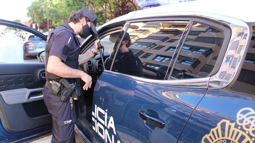 Un agente junto a un coche patrulla en Madrid.
